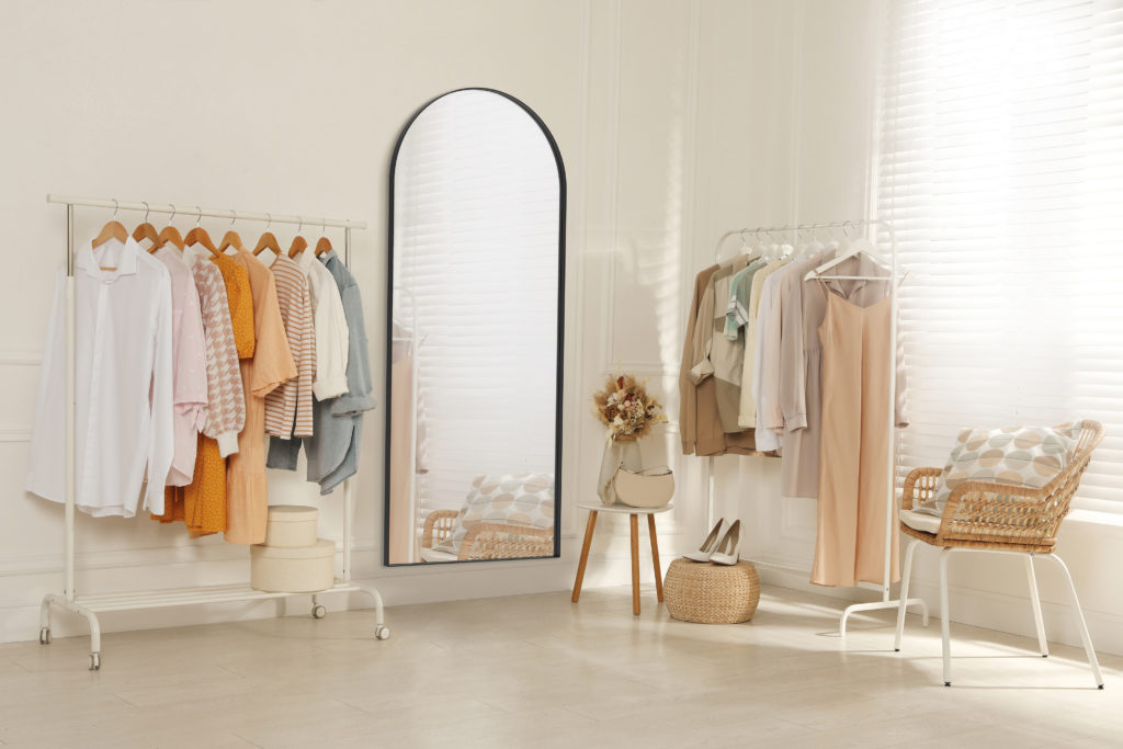 Modern dressing room interior with stylish clothes, shoes and be
