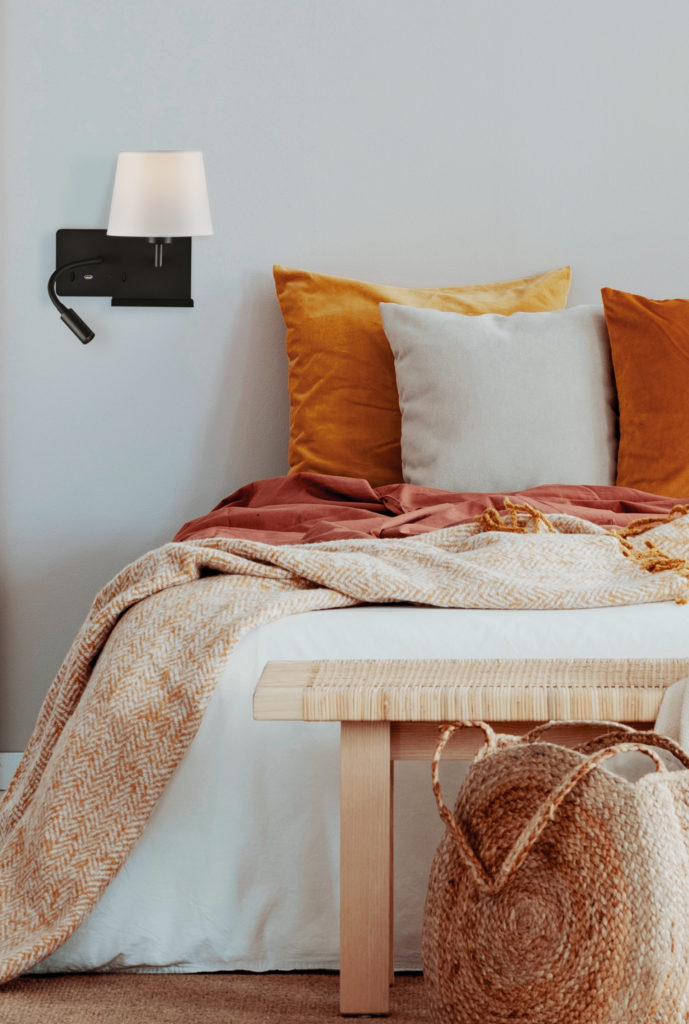 Brown and orange pillows on white bed in natural bedroom interio