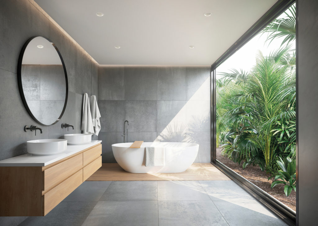 Grey concrete tiled bathroom with opening to a jungle garden a r